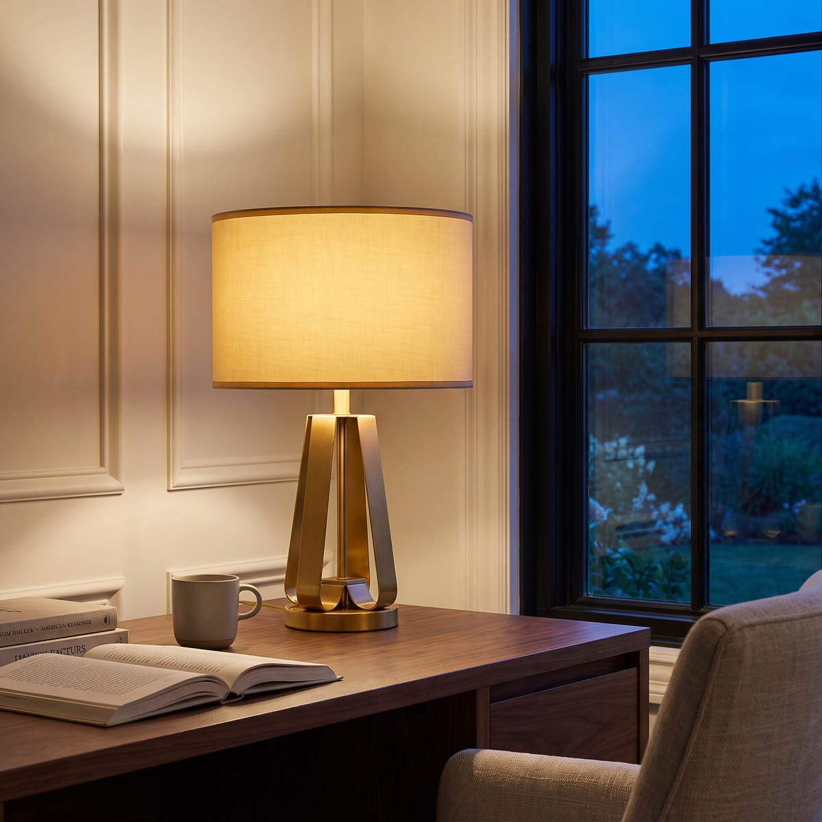 Solstice table lamp lit on a study desk