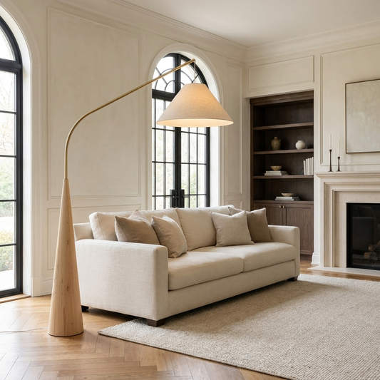 Calder arc floor lamp reaching over a cream linen sofa