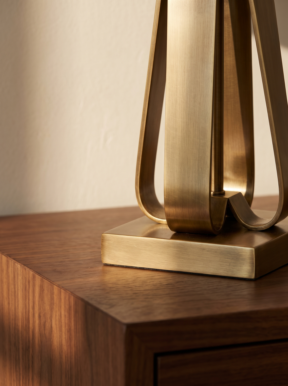 Solstice lamp brass base weight on a walnut surface